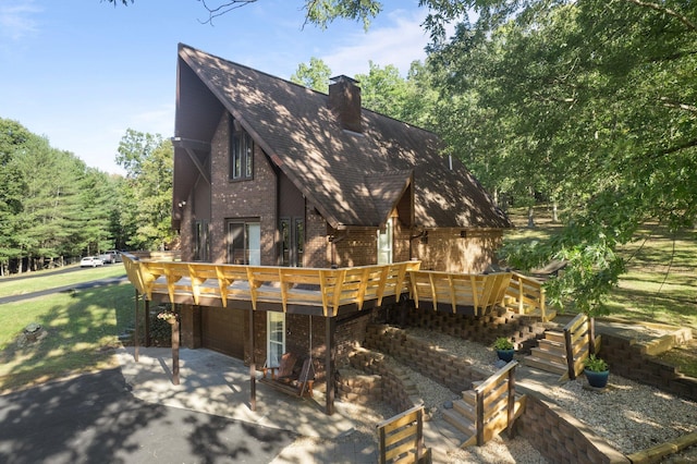 rear view of property featuring a wooden deck and a garage