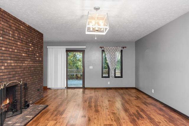 unfurnished living room with a fireplace, a textured ceiling, and hardwood / wood-style flooring