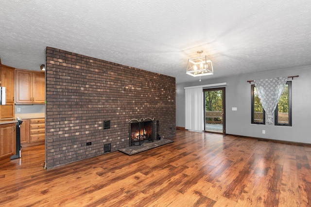 unfurnished living room with a fireplace, light hardwood / wood-style floors, and a textured ceiling