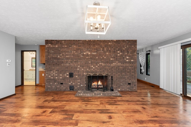 unfurnished living room featuring a fireplace, hardwood / wood-style floors, and a textured ceiling