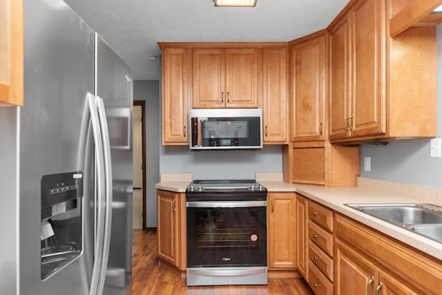 kitchen featuring sink, appliances with stainless steel finishes, and light hardwood / wood-style flooring