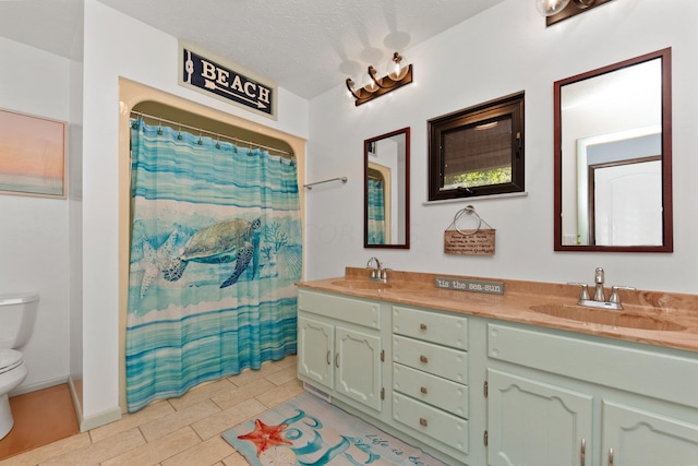 bathroom featuring a shower with curtain, tile patterned floors, a textured ceiling, toilet, and vanity