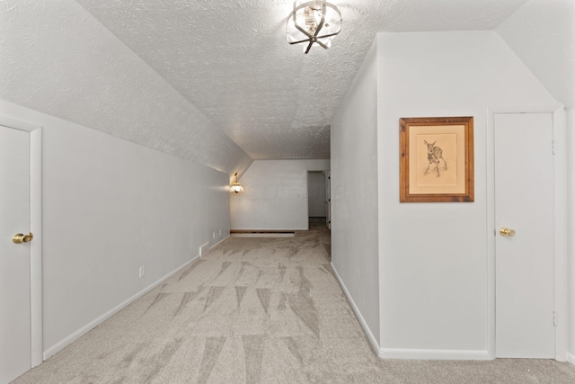 bonus room with a textured ceiling, light colored carpet, and lofted ceiling