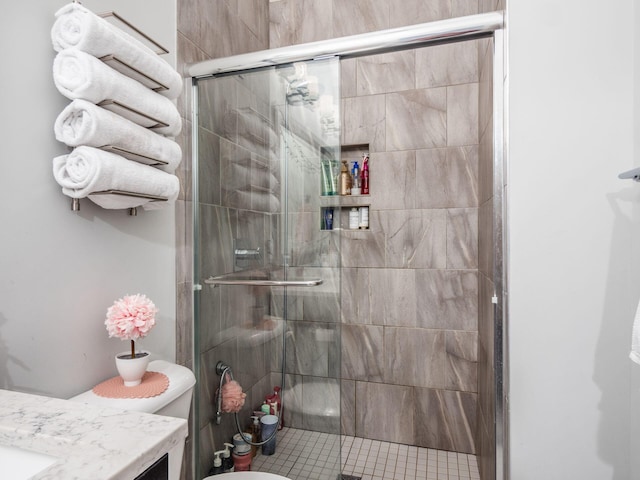 bathroom with an enclosed shower, vanity, and toilet