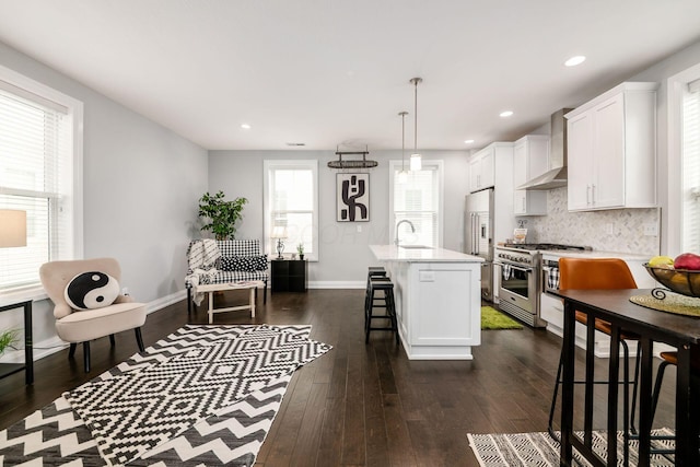 1002 Ewing Aly, Columbus, OH 43201 - kitchen with high quality appliances, wall chimney range hood, light countertops, a kitchen breakfast bar, and dark wood-style flooring