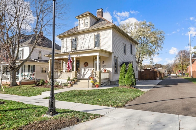 view of front facade with covered porch and a front yard