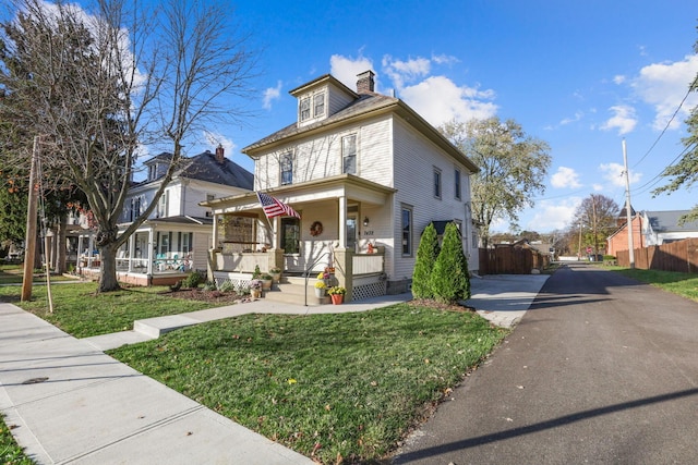 view of front of property with covered porch and a front lawn