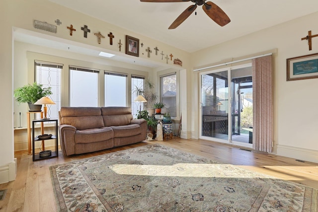 living room featuring a wealth of natural light, light hardwood / wood-style flooring, and ceiling fan