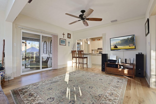 living room with ceiling fan and light hardwood / wood-style floors