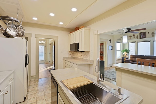 kitchen with ceiling fan, sink, white fridge, decorative backsplash, and white cabinets