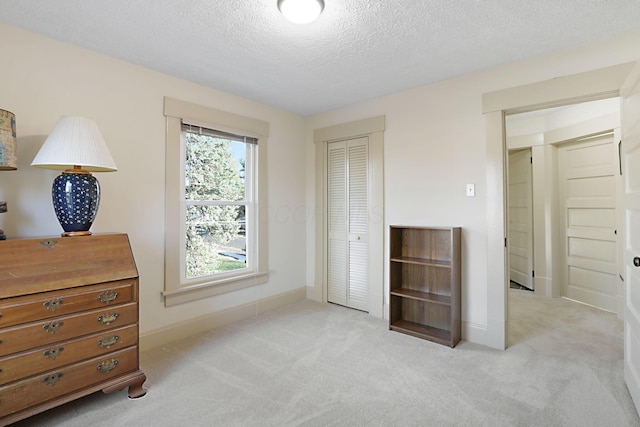 carpeted bedroom with a closet and a textured ceiling