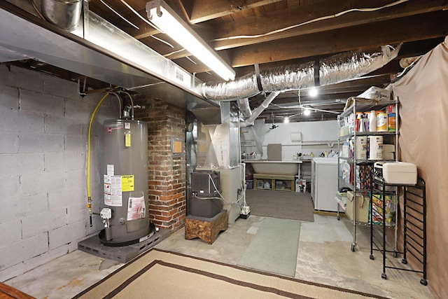 basement featuring heating unit, water heater, and washer and dryer