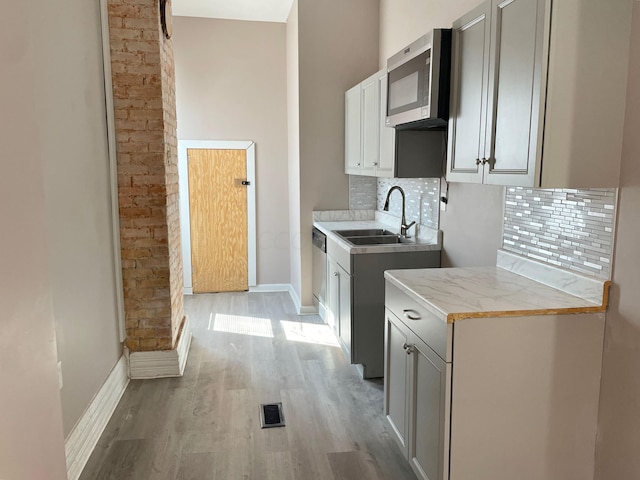 laundry area featuring sink and light wood-type flooring