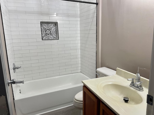 full bathroom featuring tiled shower / bath combo, toilet, and vanity