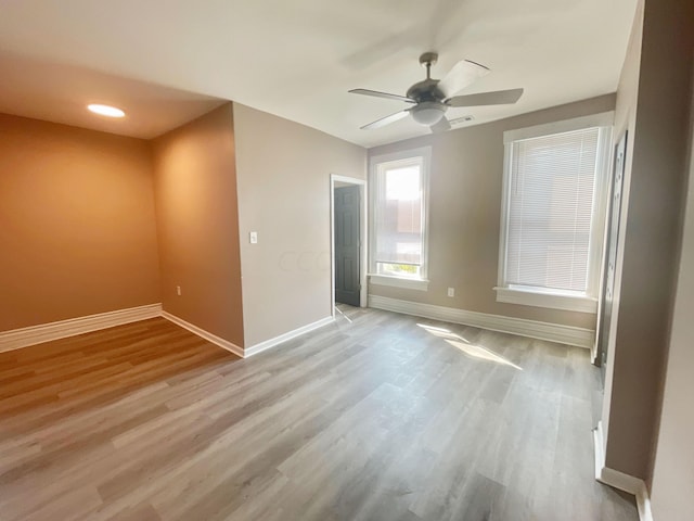 empty room with ceiling fan and light wood-type flooring