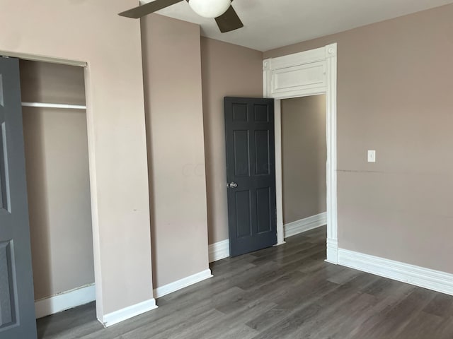 unfurnished bedroom with a closet, ceiling fan, and dark wood-type flooring