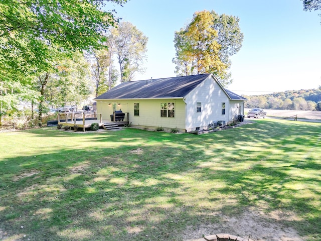 rear view of house with a deck and a yard