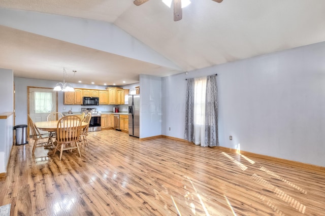 interior space featuring lofted ceiling, light wood-type flooring, and ceiling fan with notable chandelier