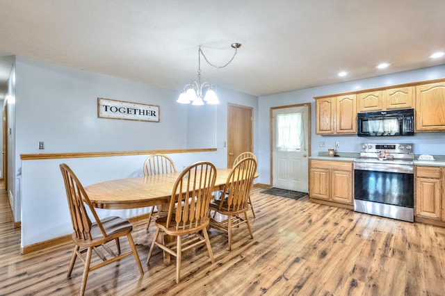 kitchen with light hardwood / wood-style flooring, hanging light fixtures, stainless steel range with electric stovetop, and a notable chandelier