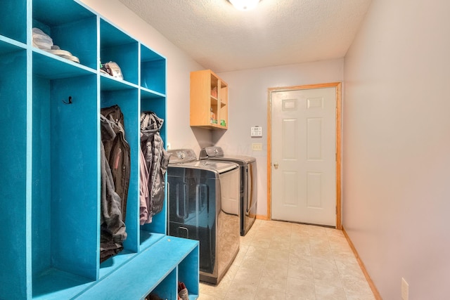 mudroom with a textured ceiling and independent washer and dryer