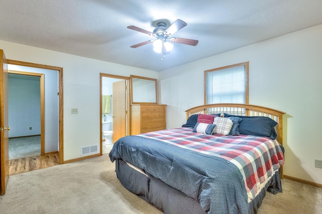 carpeted bedroom featuring connected bathroom, ceiling fan, and a textured ceiling