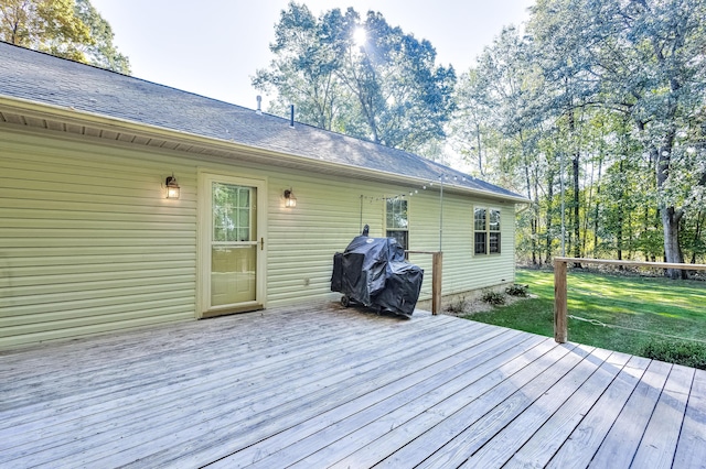 wooden terrace with a grill and a yard