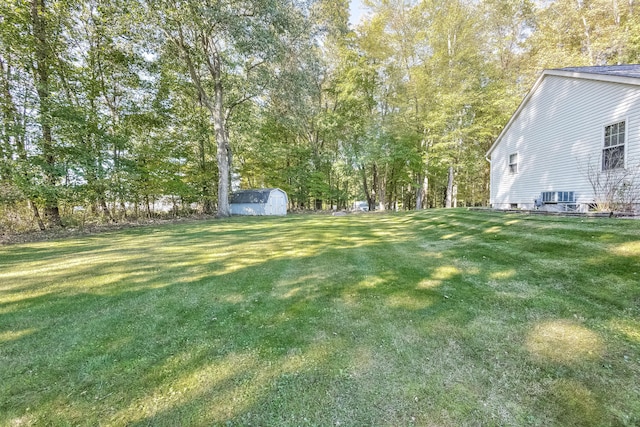 view of yard featuring a shed and central AC