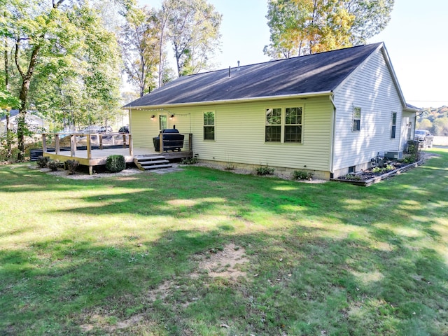 back of property with a lawn and a deck