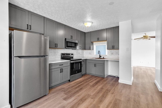 kitchen featuring gray cabinets, light hardwood / wood-style flooring, and stainless steel appliances