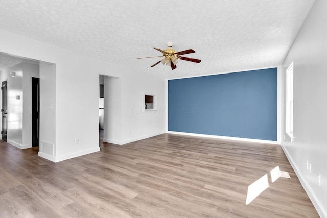 unfurnished living room featuring a textured ceiling, light hardwood / wood-style floors, and ceiling fan