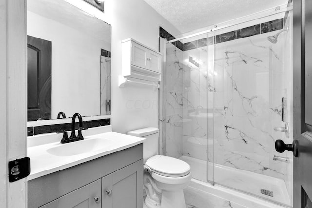 bathroom featuring an enclosed shower, vanity, toilet, and a textured ceiling