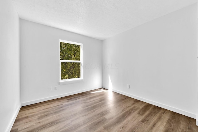 spare room with wood-type flooring and a textured ceiling