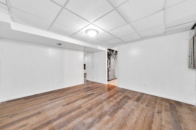 basement featuring a paneled ceiling and hardwood / wood-style floors