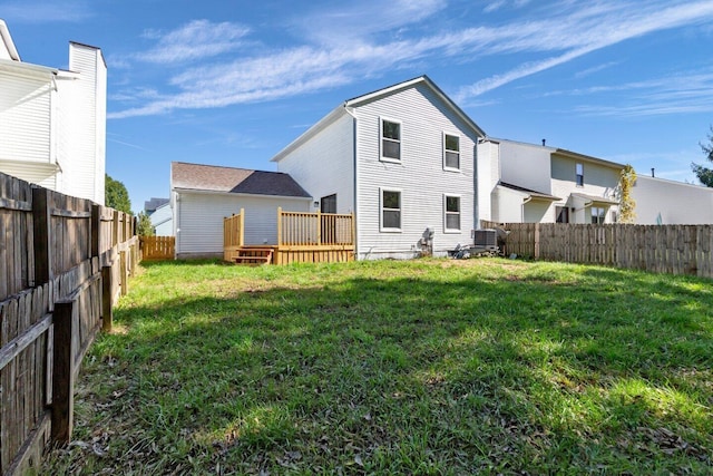 rear view of house featuring a lawn and a wooden deck