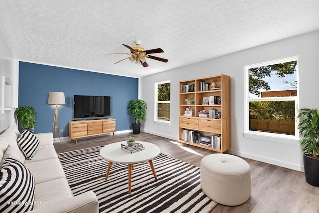 living room with ceiling fan, hardwood / wood-style floors, and a textured ceiling