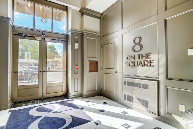 entryway with light tile patterned floors and french doors