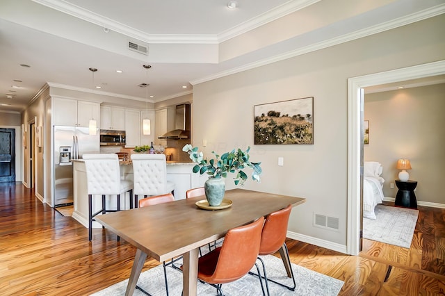 dining space featuring light hardwood / wood-style floors and ornamental molding