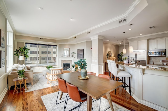 dining space featuring light hardwood / wood-style flooring and ornamental molding