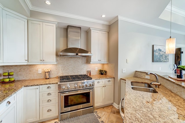 kitchen featuring white cabinetry, sink, light stone countertops, wall chimney range hood, and stainless steel stove