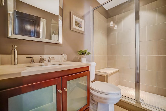 bathroom featuring vanity, toilet, and walk in shower