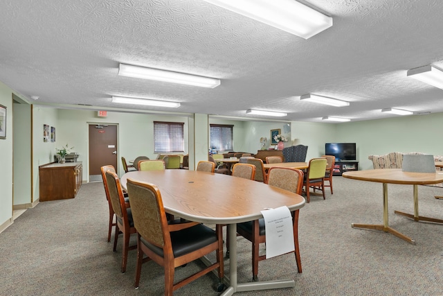 dining room with light colored carpet and a textured ceiling