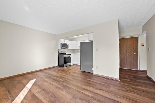 unfurnished living room with a textured ceiling and dark hardwood / wood-style flooring