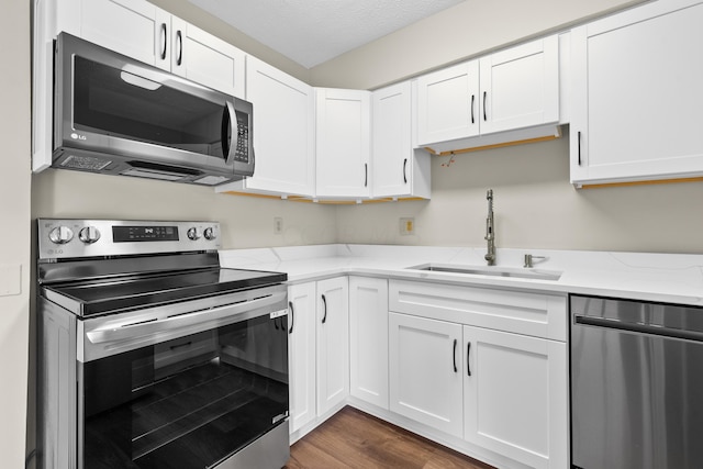 kitchen featuring white cabinetry, sink, dark hardwood / wood-style floors, and appliances with stainless steel finishes