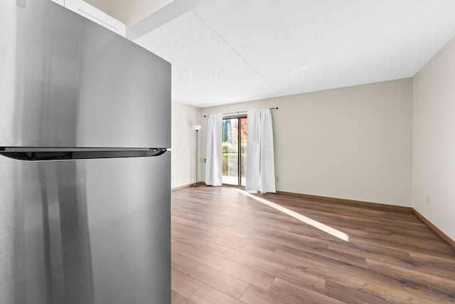 empty room with a textured ceiling and hardwood / wood-style flooring