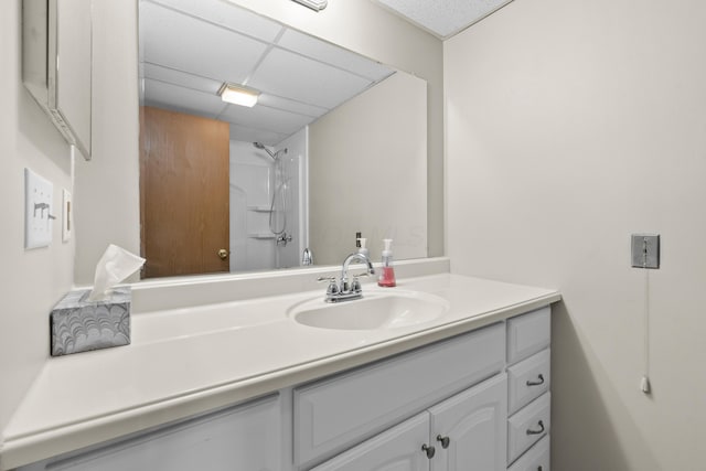 bathroom featuring a shower, a drop ceiling, and vanity