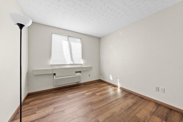 unfurnished room featuring a textured ceiling and hardwood / wood-style flooring