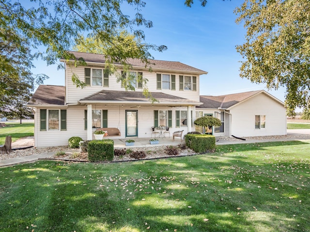 rear view of house featuring a yard and a patio