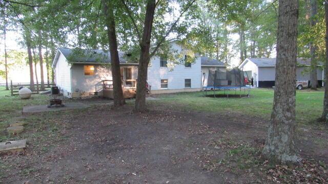 view of yard featuring a trampoline and an outdoor fire pit