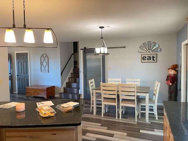 dining space with dark hardwood / wood-style flooring and a chandelier