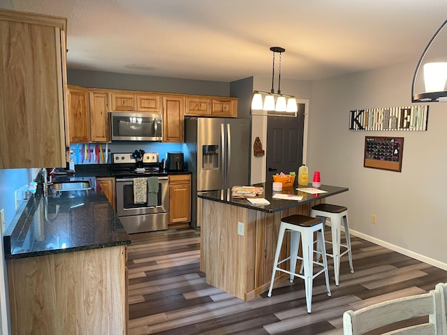 kitchen featuring pendant lighting, a kitchen island, dark hardwood / wood-style flooring, and stainless steel appliances